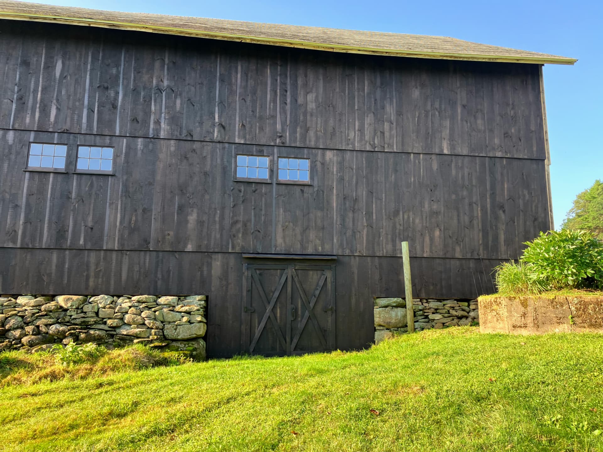 Restored barn with new dark board and batten siding and windows