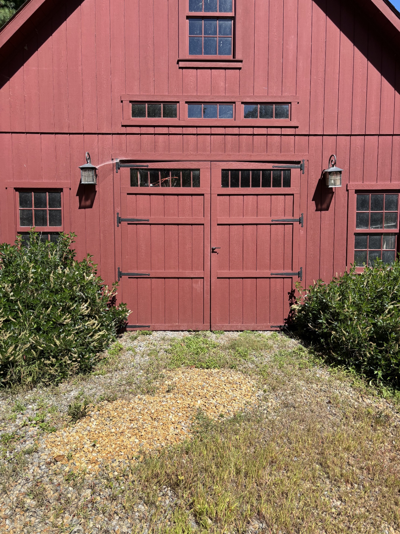 Red barn with original swinging carriage doors and gravel apron
