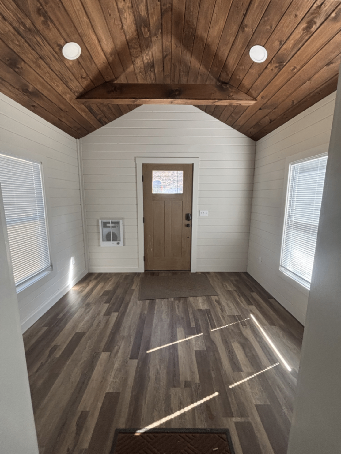 Finished mudroom entry with vaulted wood ceiling and shiplap walls