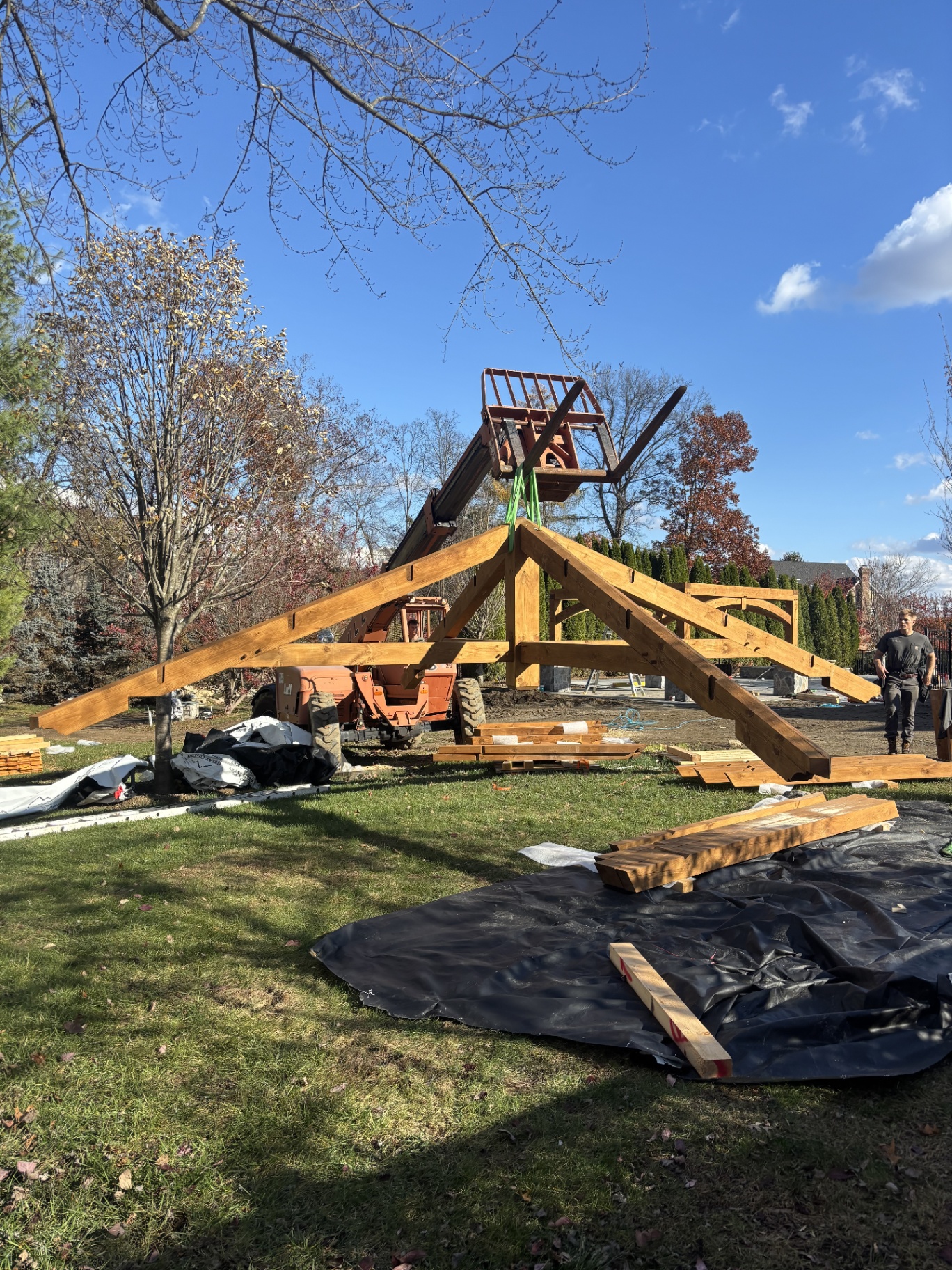 Timber frame truss being lifted into place by a telehandler during the pavilion build