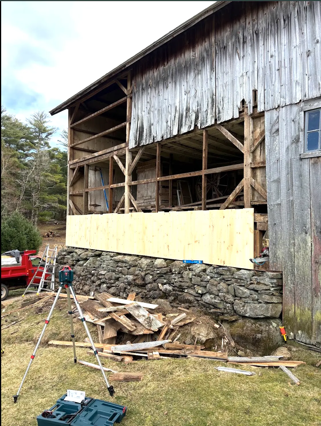 Barn with open bay and weathered siding removed before re-siding