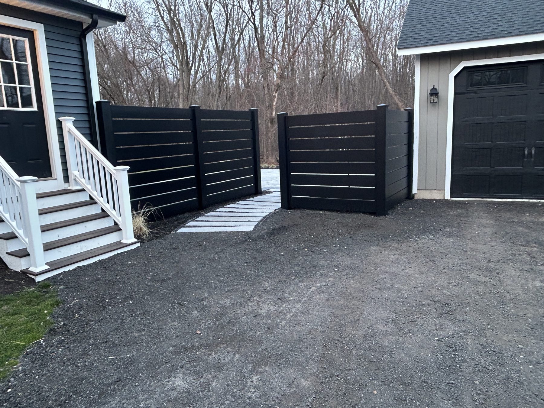 Paver driveway with black horizontal privacy fence