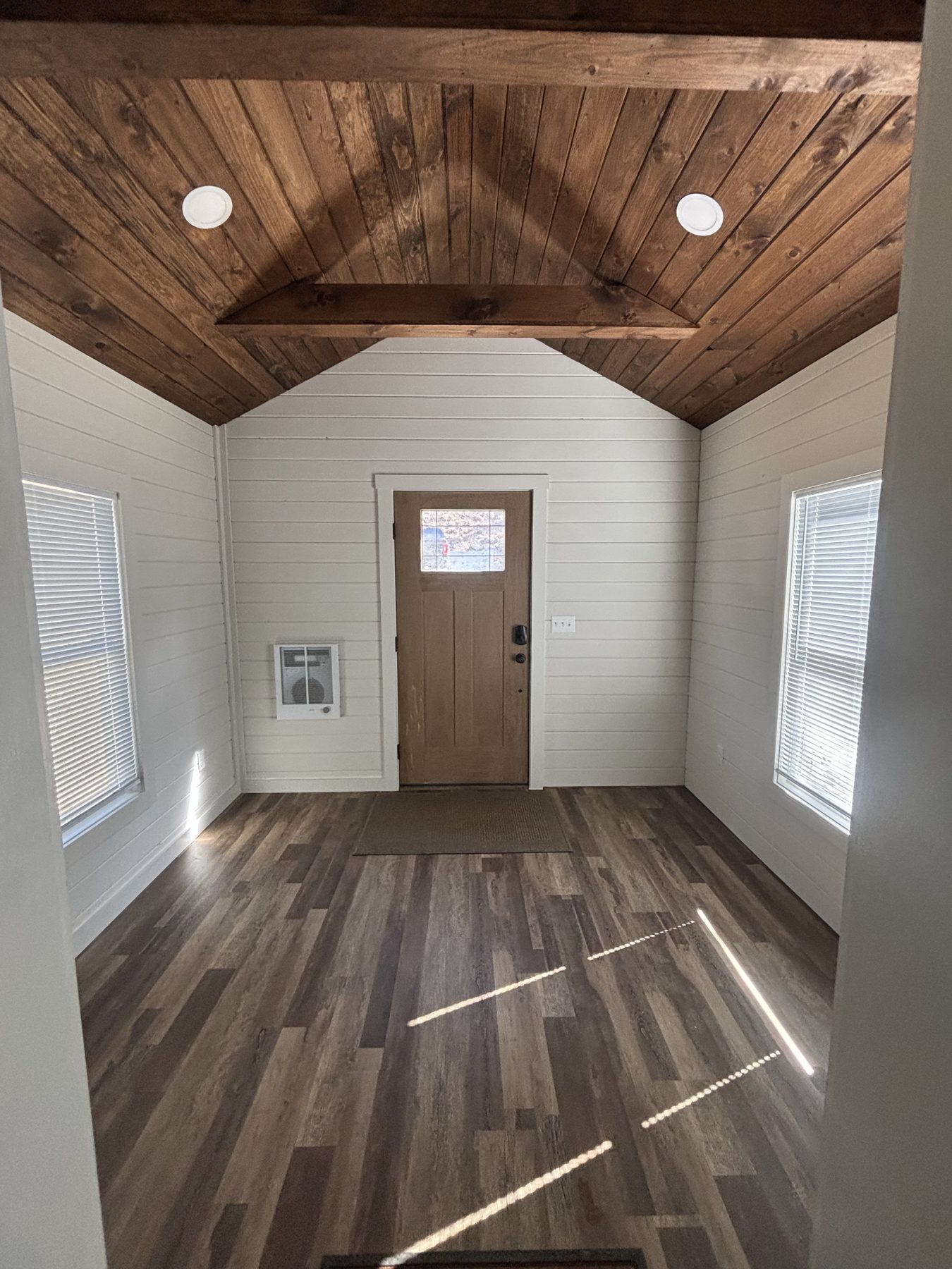 Vaulted mudroom entry with wood ceiling and side door