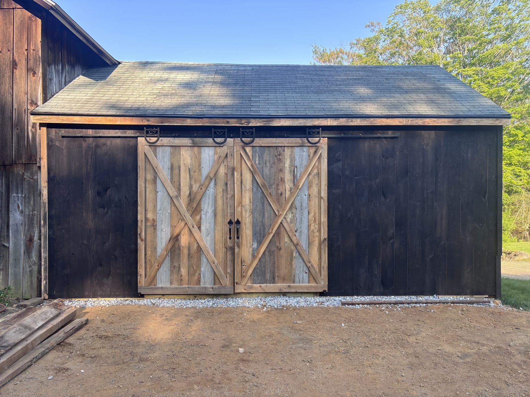 Restored dark-stained barn with new roof and doors