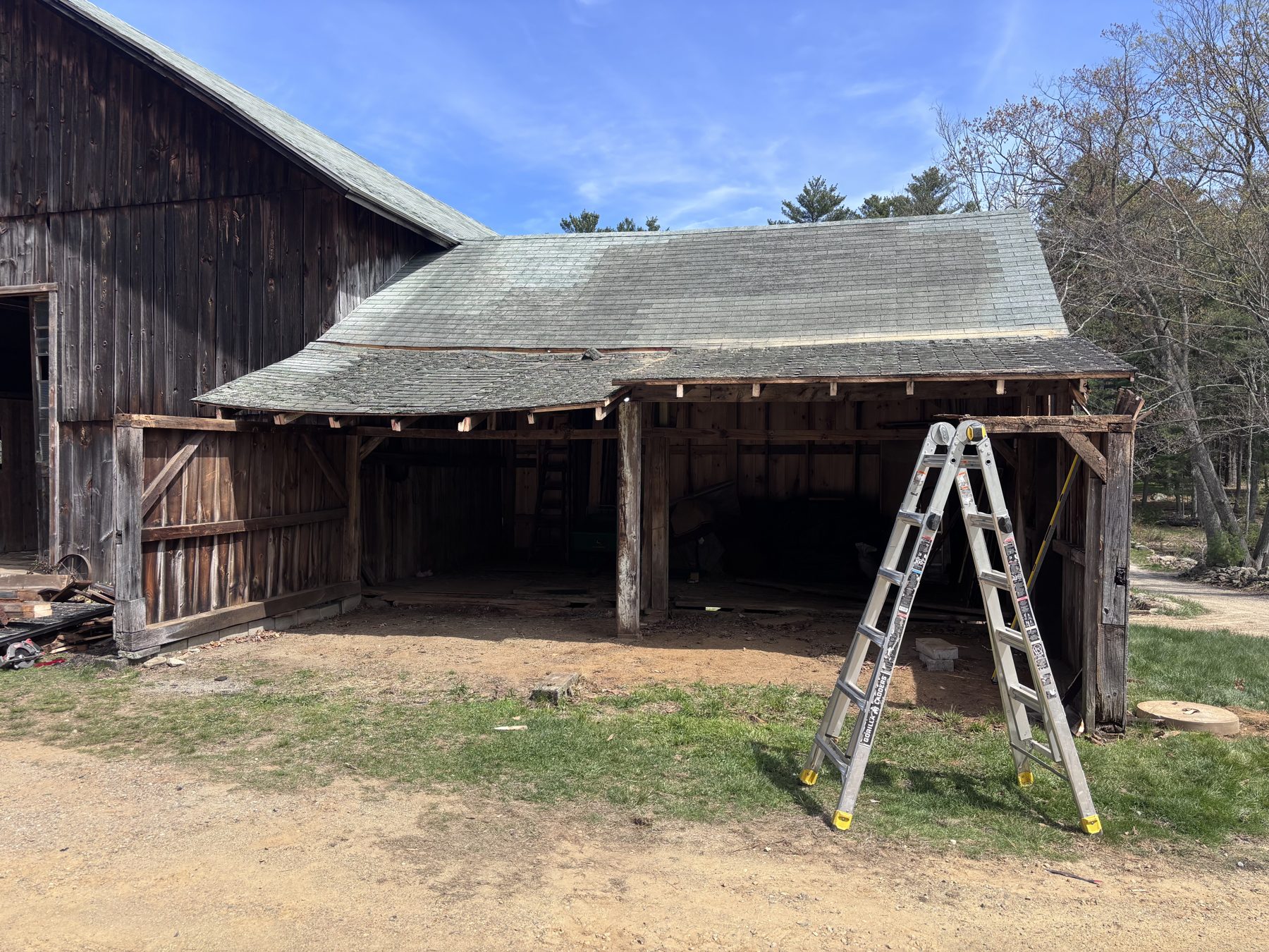Weathered barn with sagging bay before restoration