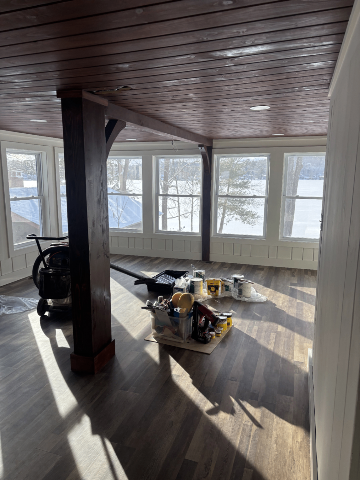 Finished lakeside porch with stained wood ceiling, timber post and lake views