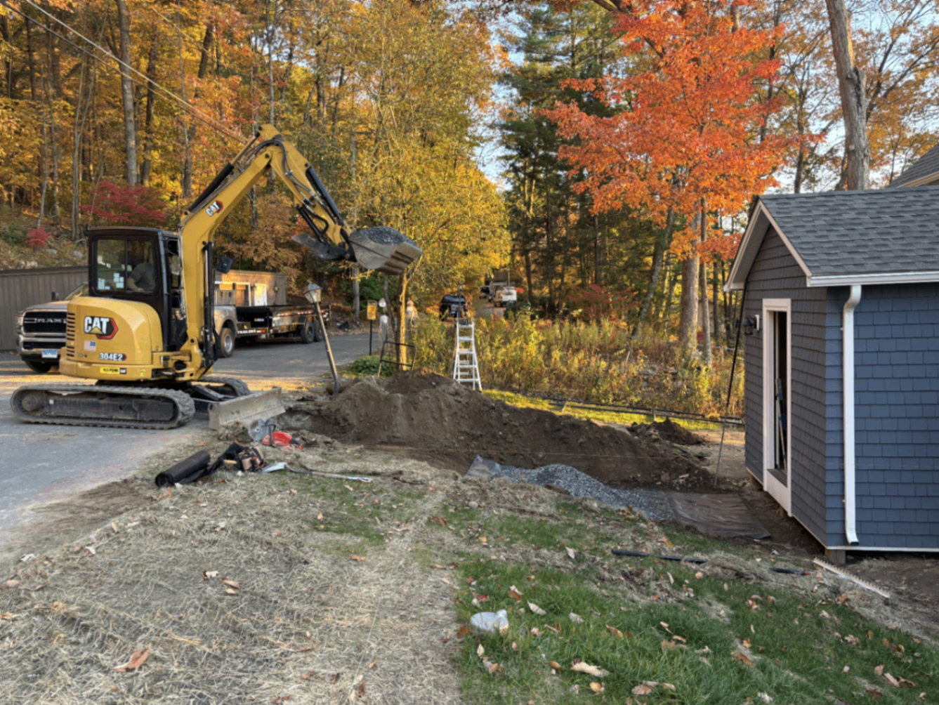 Excavator trenching and grading the front yard before walkway install