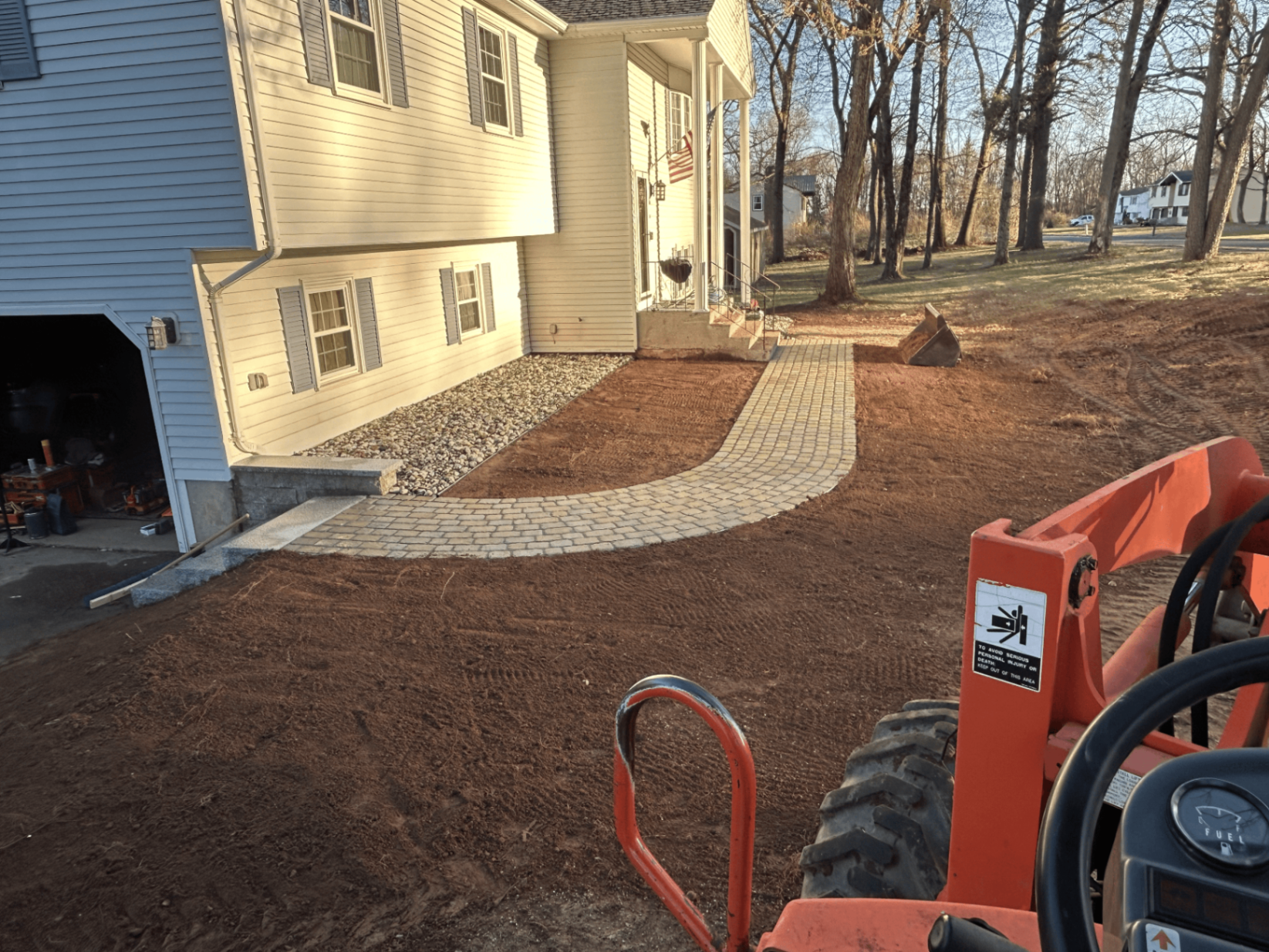 Curved paver walkway with granite steps and stone veneer at the entry