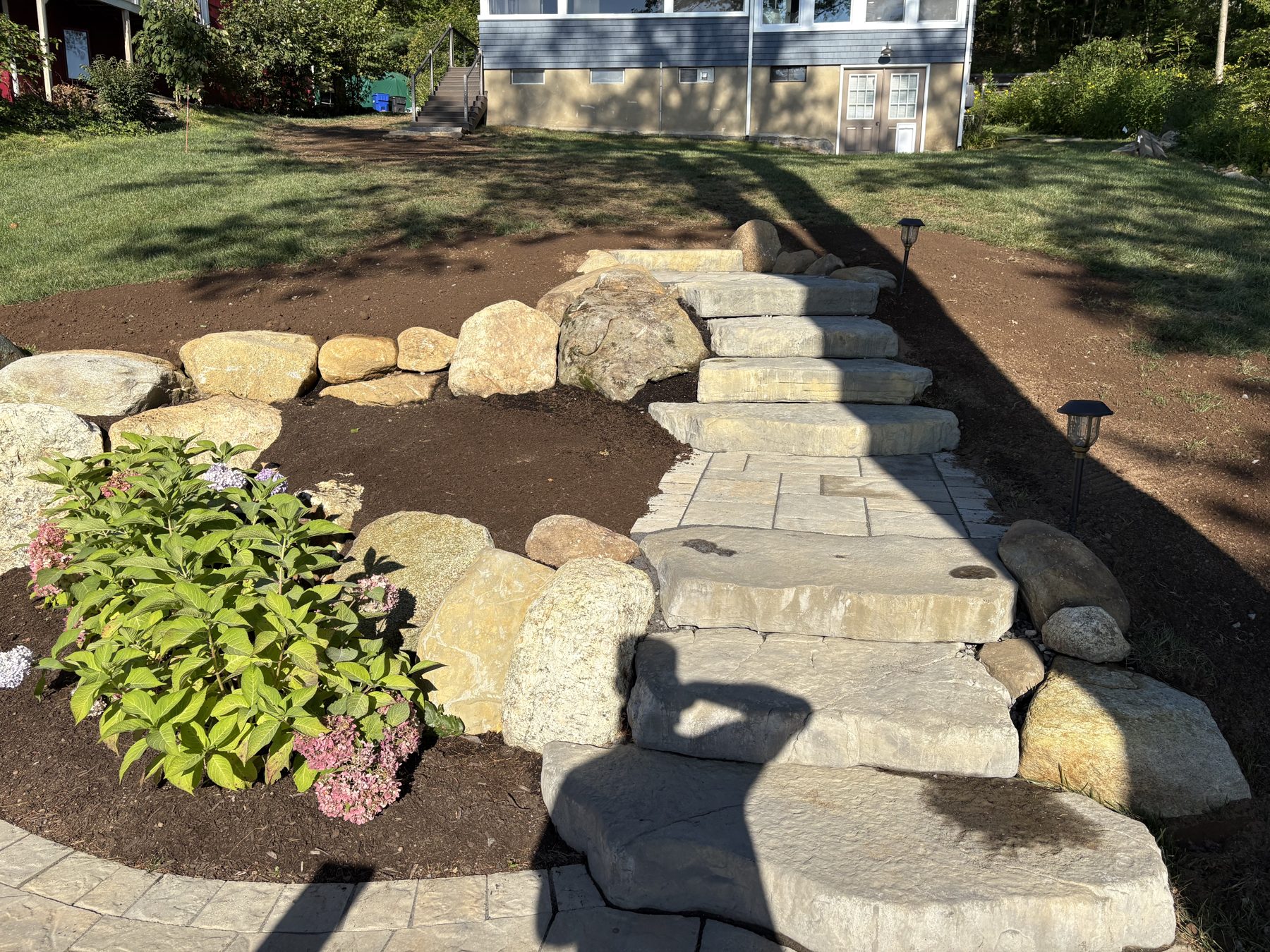 Natural stone steps through boulder landscape beds