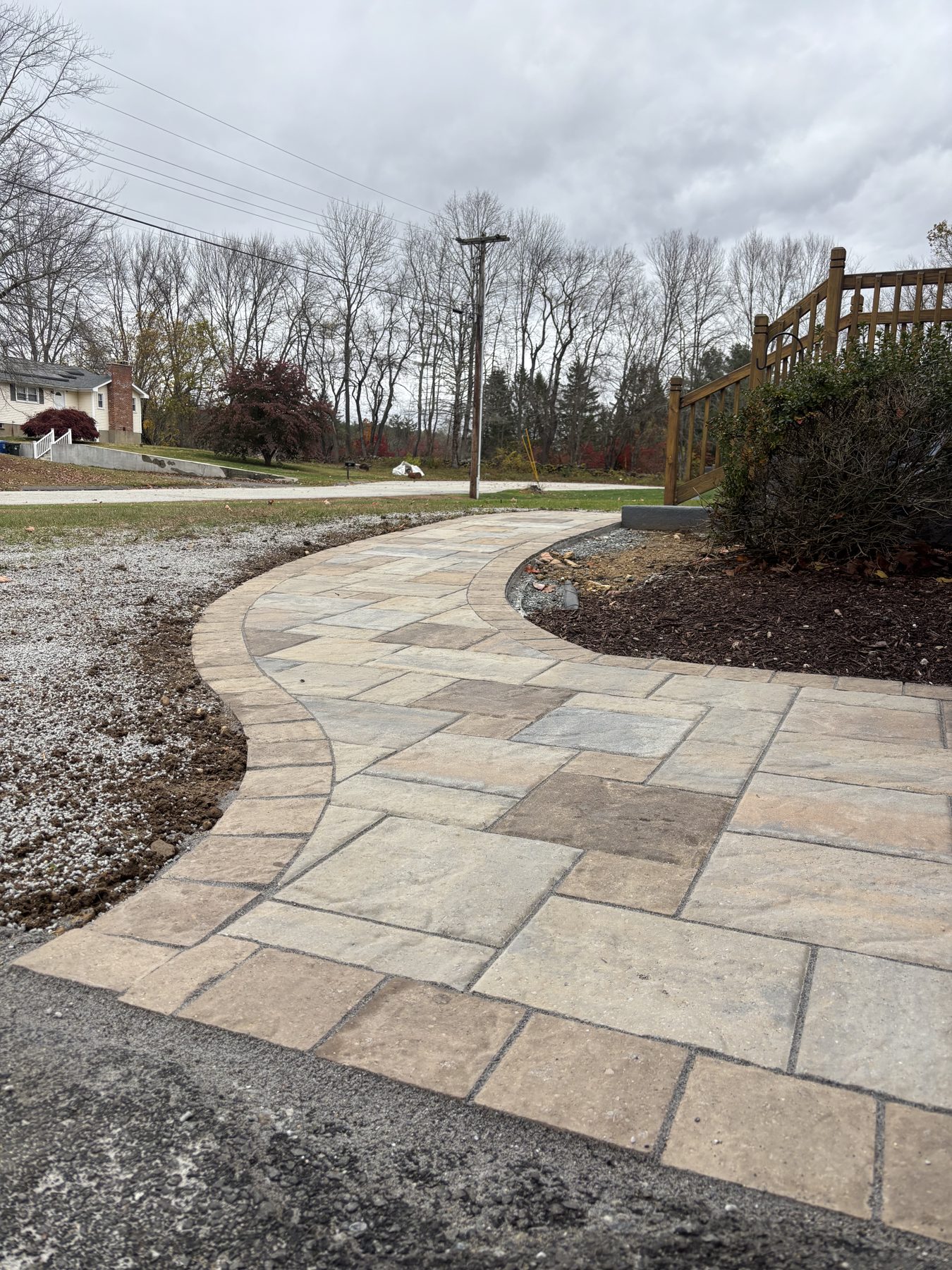 Curved bluestone walkway through landscape beds
