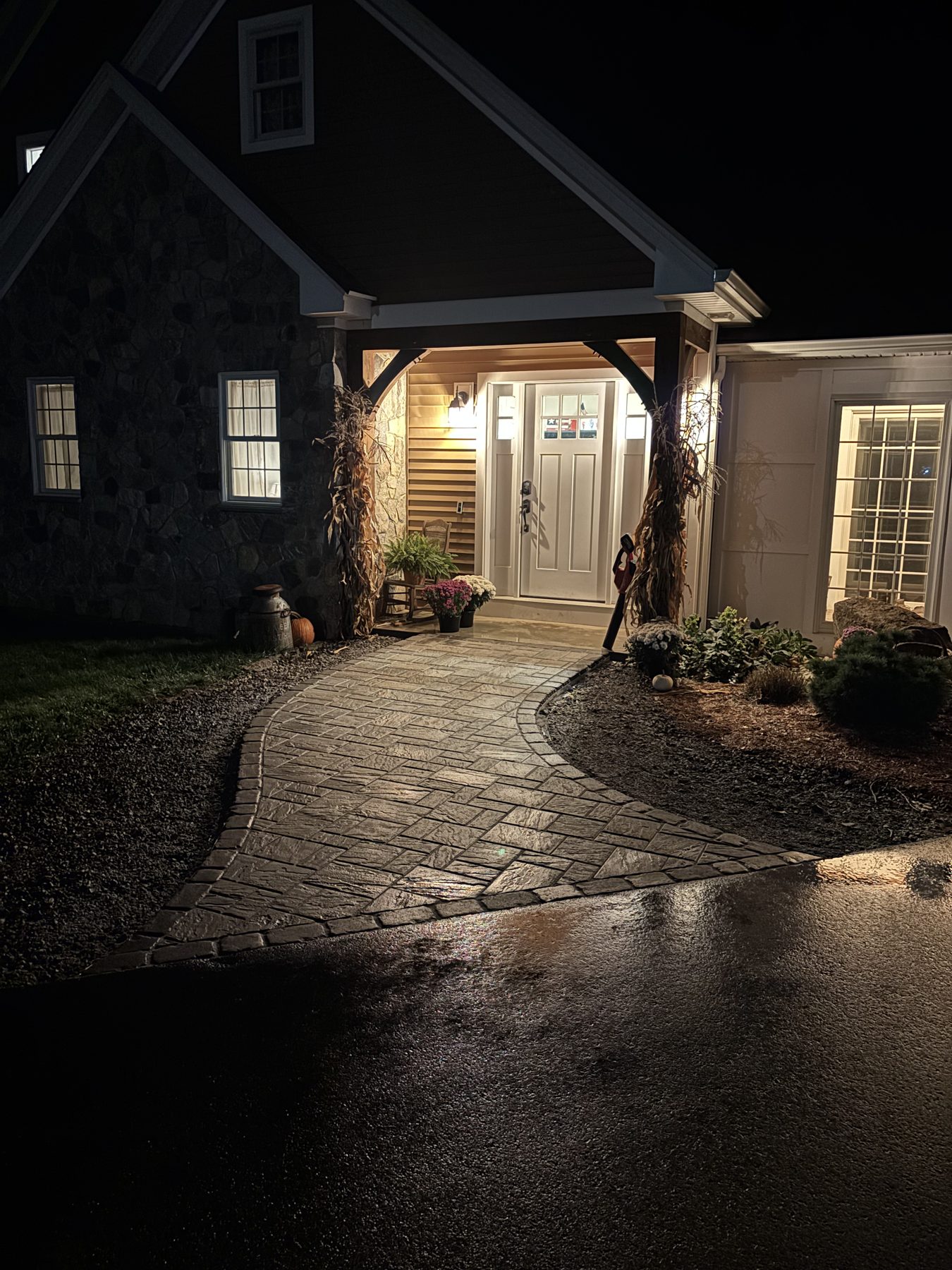 Stone-front craftsman home lit at night